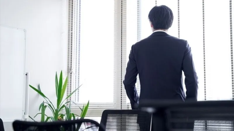 オフィスにいるスーツ姿の男性の背姿